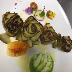 Flor de alcachofa confitada con papa especiada, crema de guisantes y decoración floral gourmet